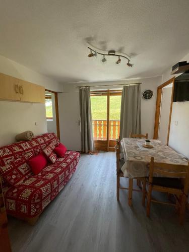un salon avec un canapé rouge et une table dans l'établissement Appartement convivial à Thollon-les-Mémises, 35 m², vue montagne, à Thollon-les-Mémises