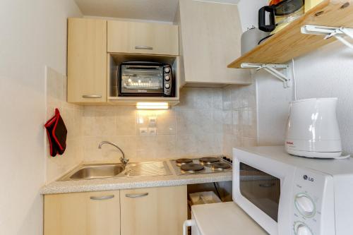 a small kitchen with a sink and a microwave at Appartement convivial à Thollon-les-Mémises, 35 m², vue montagne in Thollon