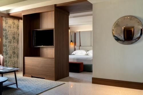 a hotel room with a bed and a television at Ca' di Dio - VRetreats, an SLH Hotel in Venice