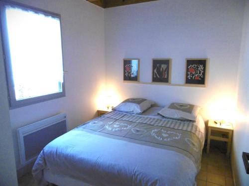 a bedroom with a bed with two lamps and a window at Maison 4 pièces 5 personnes à 200 m de la plage - MAIANN in Sarzeau