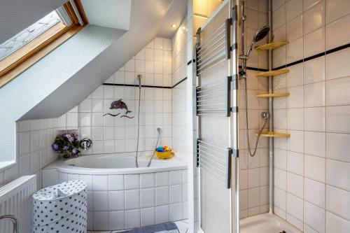 une salle de bains avec baignoire et lavabo dans l'établissement Ferienwohnung Wittensee, à Bünsdorf