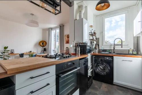 a kitchen with a stove and a sink at Le Loft de l'Artiste in Sèvres