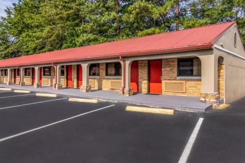 a building with a red roof in a parking lot at Americas Best Value Inn Opelika in Opelika