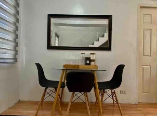 a table with chairs and a mirror on a wall at Modern Home Near MOA and NAIA in General Trias