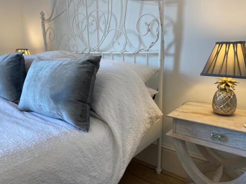 a bedroom with a bed and a table with a lamp at Deluxe Three Bed BnB in Henley-on-Thames near Station River & Town Centre in Henley on Thames