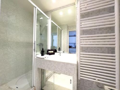 une salle de bain avec un lavabo et un grand miroir dans l'établissement Charmant Studio avec terrasse et vue arborée, à Cannes