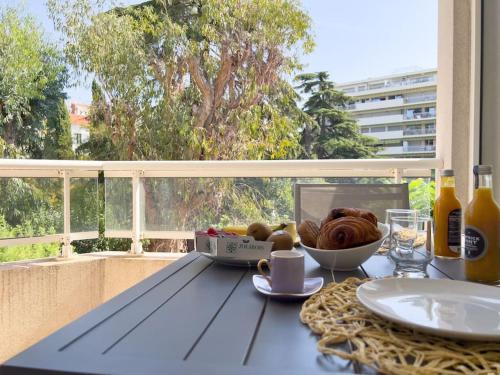 - une table avec un bol de pain et une assiette de nourriture dans l'établissement Charmant Studio avec terrasse et vue arborée, à Cannes