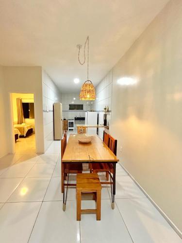 a kitchen and dining room with a wooden table and chairs at Casa Sóumi - Ubajara/CE in Ubajara