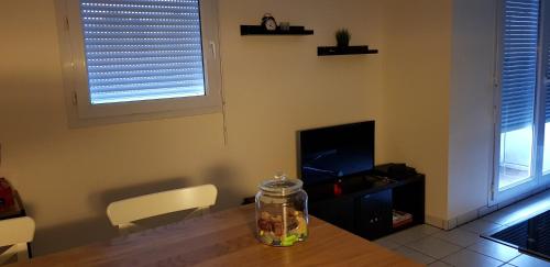 un salon avec une table et une télévision dans l'établissement Nantes, à Rezé