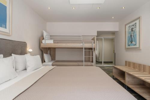 a bedroom with a large bed and bunk beds at Piraeus City Hotel in Piraeus