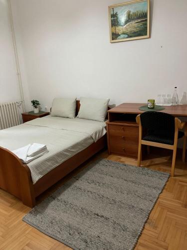a bedroom with a bed and a desk and a table at Hotel Vlasina - Vlasinsko jezero in Lujinska Mala