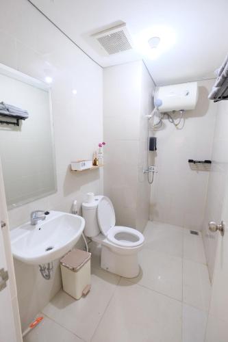a white bathroom with a toilet and a sink at Delipark Mall 2 Bedrooms 1 Bathroom 4-6 Pax Lexington Tower Level 7 in Medan