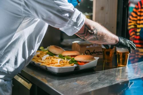 a chef preparing a tray of hamburgers and french fries at Chalet Cima Uomo in Passo San Pellegrino