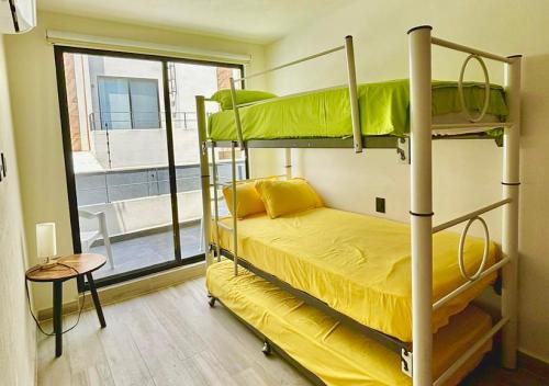 a bedroom with two bunk beds and a window at A pie de Alberca, Parking, Llegada Autonoma, Duermen 12, Pet FRIENDLY in Xochitepec