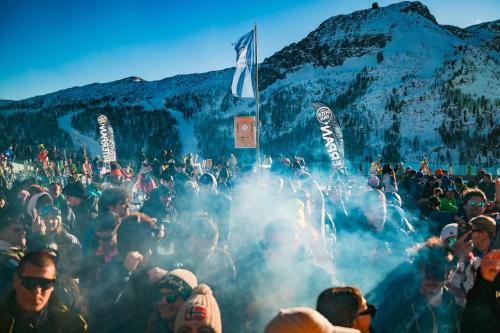 a large group of people standing around in smoke at Chalet Cima Uomo in Passo San Pellegrino