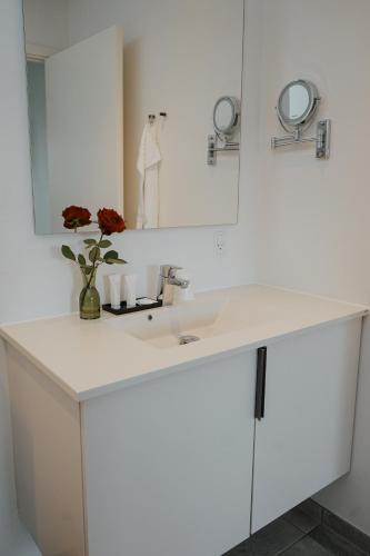 a white bathroom with a sink and a mirror at Hotel Phønix in Holstebro