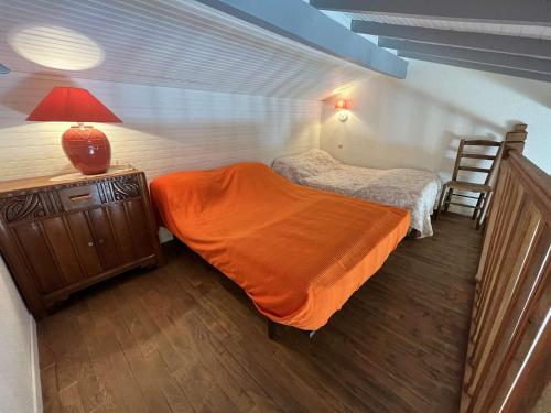 - une chambre avec 2 lits et une lampe sur une commode dans l'établissement Villa calme avec jardin clos, à 800m de la plage et 600m des commerces à Brétignolles-sur-Mer - FR-1-324-198, à Bretignolles-sur-Mer