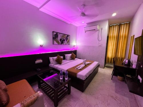 a purple room with a bed and a couch at The कस्तूरी in Maihar