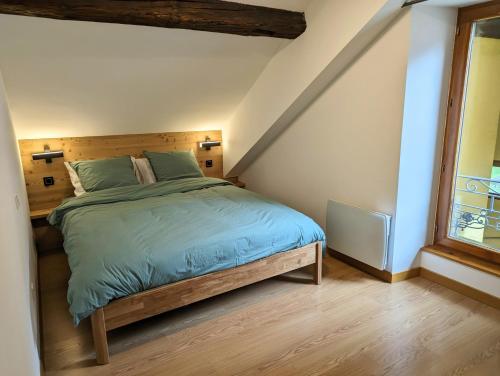 une chambre avec un lit avec une tête de lit en bois dans l'établissement Beau Duplex 100m2 au cœur de Beaufort - avec vue montagnes, à Beaufort