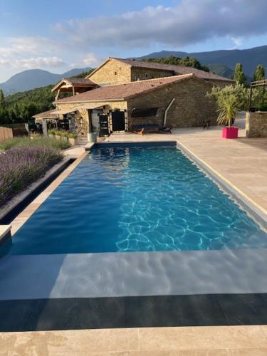 a large blue swimming pool in front of a house at Domaine de Chabanne in Crupies