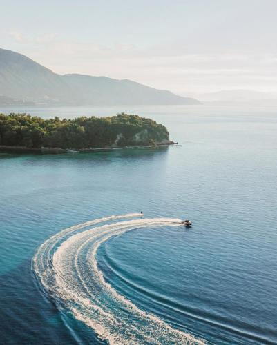 an island in the middle of the water with a boat at Ikos Dassia in Dassia