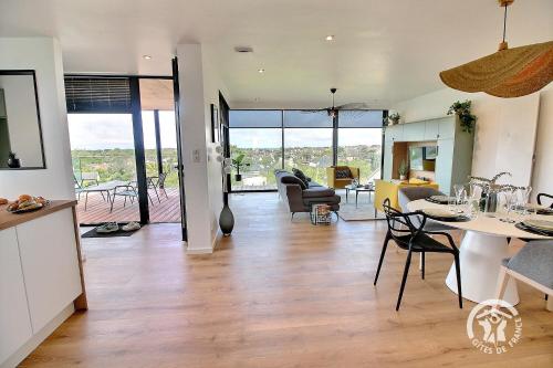 une cuisine et un salon avec une table et des chaises dans l'établissement The black house, à Trégastel