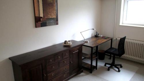 a desk with a lamp and a chair in a room at Fewo Deister Bikertraum in Wennigser Mark