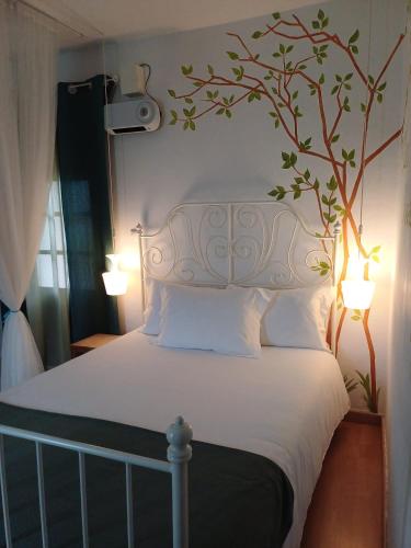 a bedroom with a bed with a tree mural on the wall at TEA HOUSE GERÊS in Geres