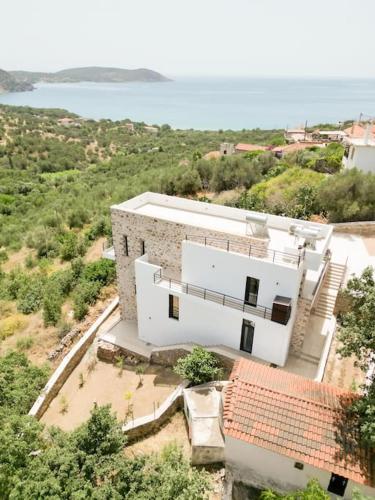 an aerial view of a white building with the ocean at Elaída - Studio,Θέα θάλασσα & βουνό,Μάνη in Skoutarion