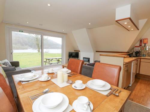 a dining room with a table and a kitchen at Lodge 2 - Inglewood Lodge in Spean Bridge