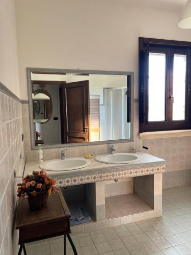a bathroom with two sinks and a large mirror at Villa Laura in Neviano