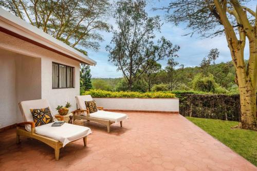 a patio with two chairs and a table at Fairmont Mount Kenya Safari Club in Nanyuki