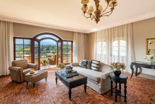 a living room with a couch and a piano at Fairmont Mount Kenya Safari Club in Nanyuki