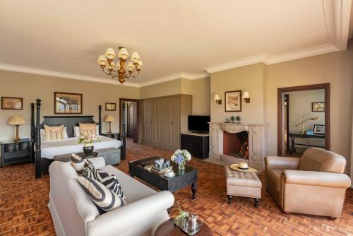a living room with a bed and a fireplace at Fairmont Mount Kenya Safari Club in Nanyuki