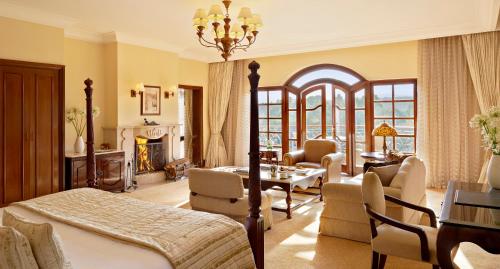 a bedroom with a bed and a living room at Fairmont Mount Kenya Safari Club in Nanyuki