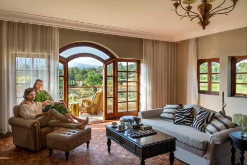 two women sitting on a couch in a living room at Fairmont Mount Kenya Safari Club in Nanyuki