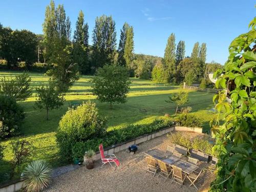 - un jardin avec une table de pique-nique et des chaises dans un champ dans l'établissement La Grange - Hameau de Montmelian, à Vulaines-sur-Seine