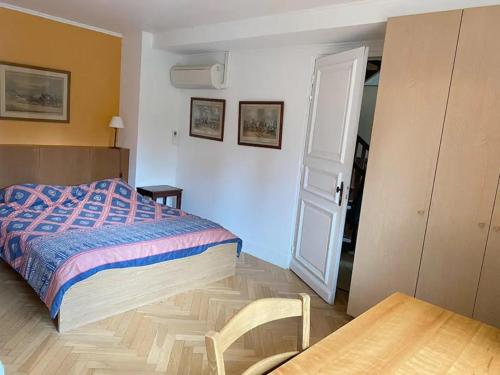 - une chambre avec un lit, une table et une porte dans l'établissement La Grange - Hameau de Montmelian, à Vulaines-sur-Seine