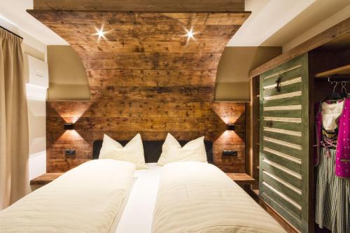 a bedroom with two beds and a brick wall at Chalet Da Mont in Selva di Val Gardena