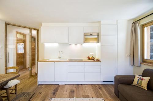 una cucina con mobili bianchi e un lavandino di Chalet Da Mont a Selva di Val Gardena