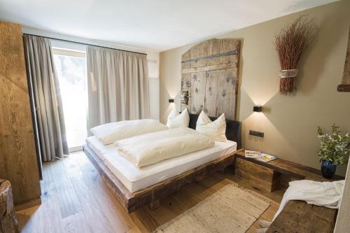 een slaapkamer met een groot bed met een houten hoofdeinde bij Chalet Da Mont in Selva di Val Gardena