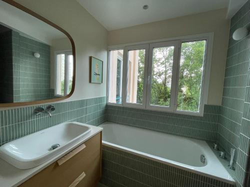 une salle de bain avec une baignoire, un lavabo et un miroir dans l'établissement Atelier d'artiste, vue Tour Eiffel, à Paris
