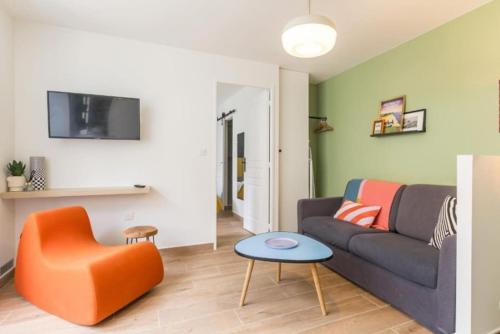 un salon avec un canapé et une chaise dans l'établissement En plein cœur d'Arromanches - Coté Digue, à Arromanches-les-Bains