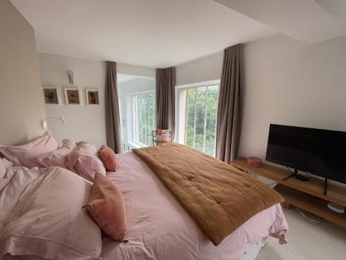 une chambre avec un grand lit et une télévision à écran plat dans l'établissement Atelier d'artiste, vue Tour Eiffel, à Paris