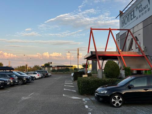 a parking lot with cars parked in front of a hotel at HOTEL PARIS VALENCE in Bourg-de-Péage