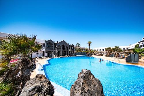 ein großer Pool mit Felsen in einem Resort in der Unterkunft Coral Cotillo Beach in Cotillo