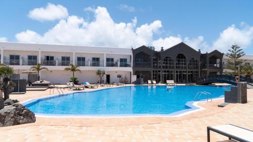 a large swimming pool in front of a building at Coral Cotillo Beach in Cotillo