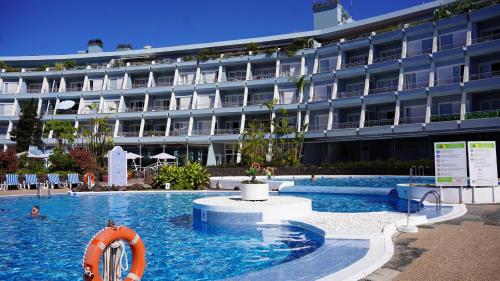 a swimming pool in front of a large building at Coral La Quinta Park Suites in Santa Úrsula