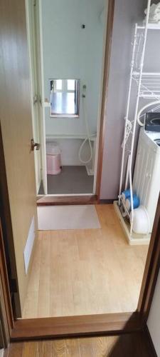 a room with a bathroom with a mirror and a hallway at はうす41マイルズ in Katakai