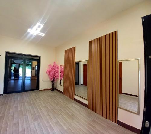 a room with a hallway with a vase of pink flowers at Hotel Vlasina - Vlasinsko jezero in Lujinska Mala